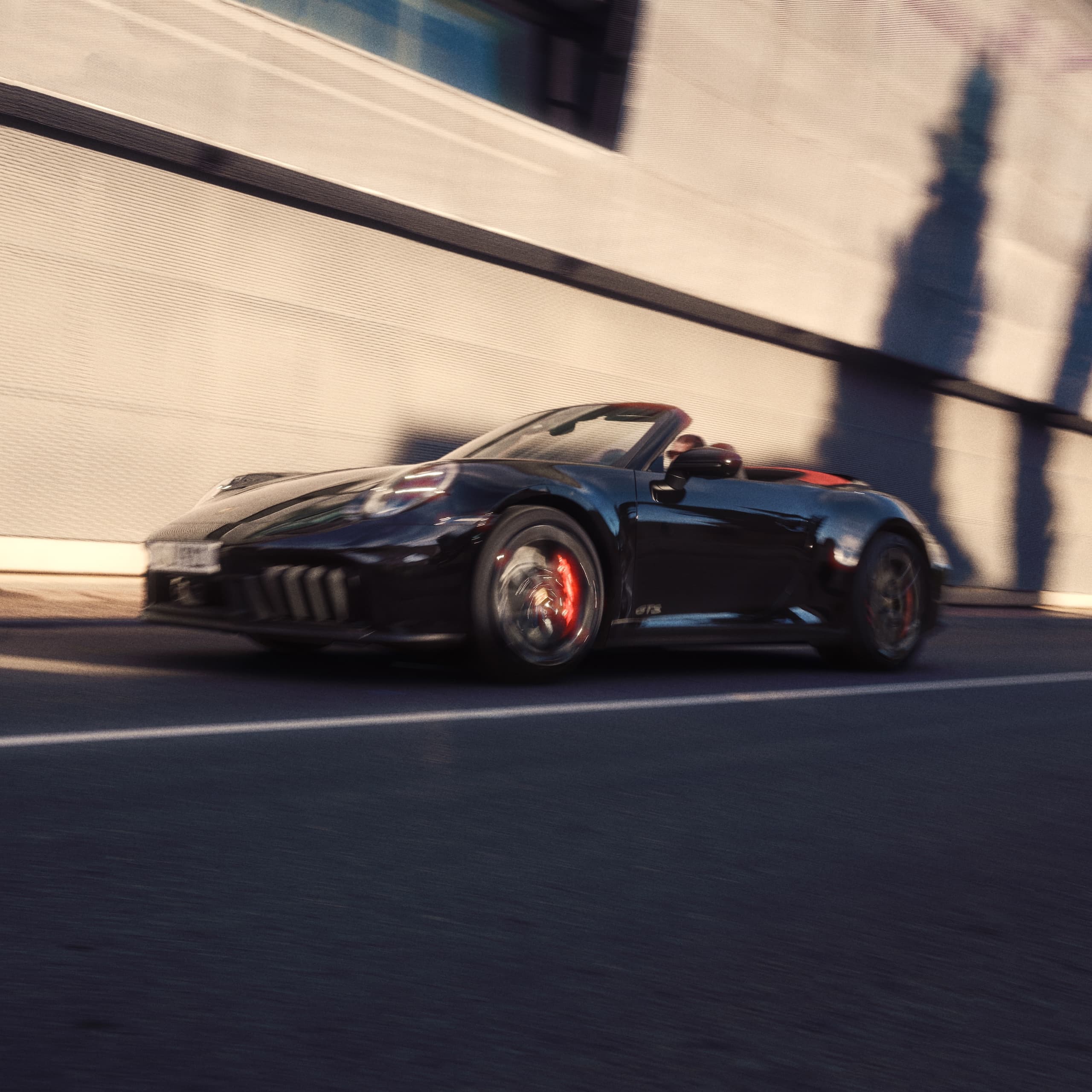 A Porsche 911 driving down a road.